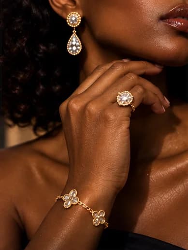 Diamond drop earring, ring and gold bracelet worn by a woman